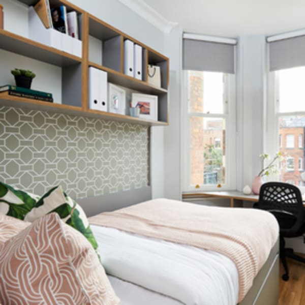 a bedroom with a window facing out onto a residential street