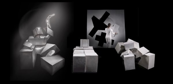 Black and white image of  performer moving with cubes.
