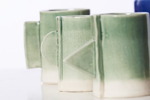a line of green grey glazed ceramic pots 