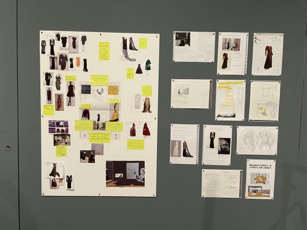 Pages from fashion designers' sketchbooks hung on the wall.