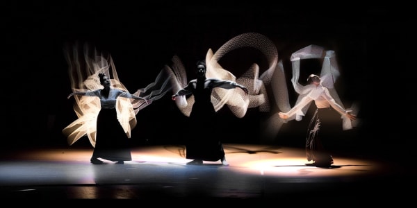 three dancers against black
