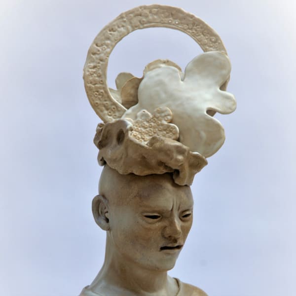 A ceramic design of a human face with a floral halo