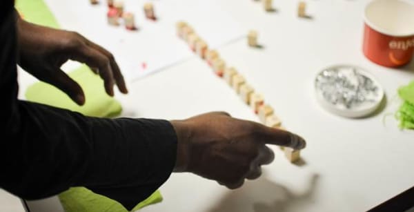 photograph of hands lining up dices on a table