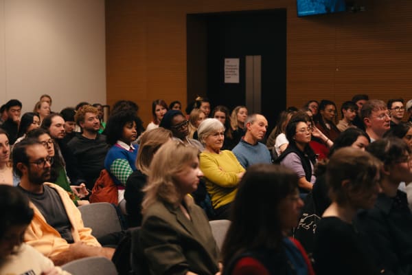 Public attending an event and listening to the panel talk