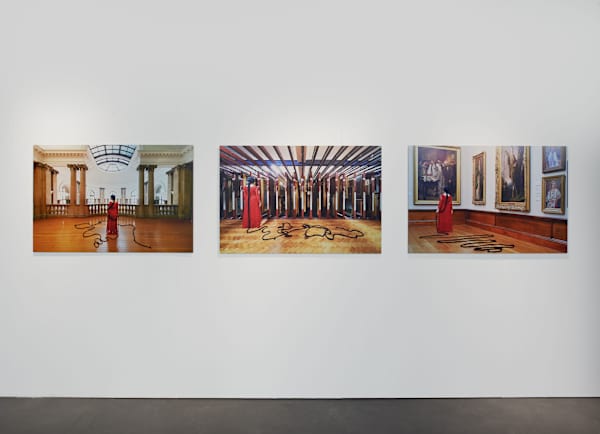View of three exhibition pieces featuring a woman in a red dress and very long plait that stretches out across the floor