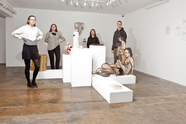 Student stood next to a gallery installation 