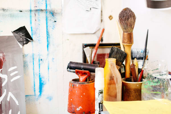 Collection of art tools and materials including paint and paintbrushes