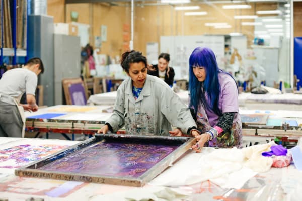 Technician and a student working on a fabric print in a fashion studio
