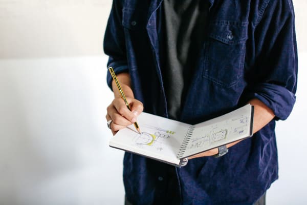 Man drawing in a sketchbook. BA (Hons) Design Management, Sketchbook by Jessy Heikrujam. Copyright holder: Alys Tomlinson