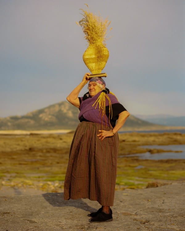 A woman carrying a scallop shaped basket on her head