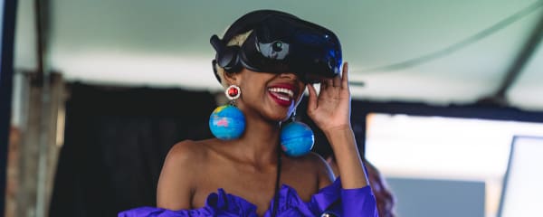 Student in VR headset and wearing globe earrings