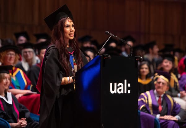 Graduate speaker at podium speaking at the graduation ceremony.