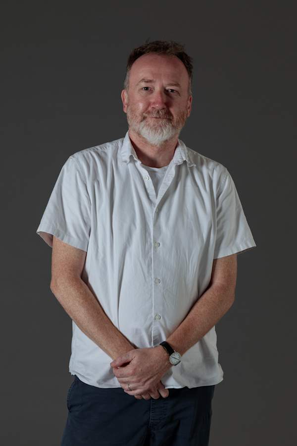 A portrait of Tony Quinn shot from the waist up.