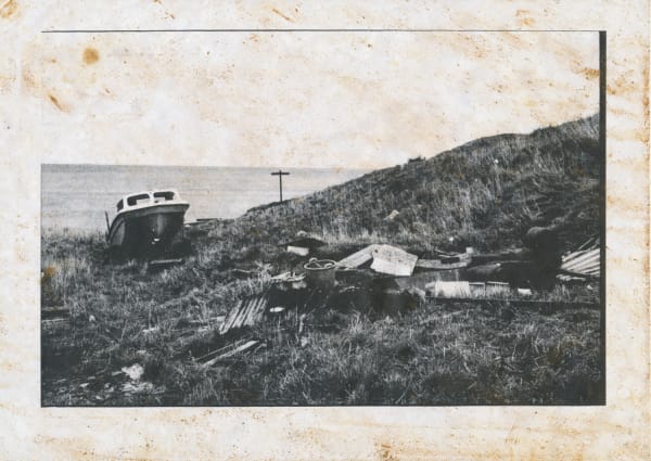 Black and white photograph of a boat on a clifftop