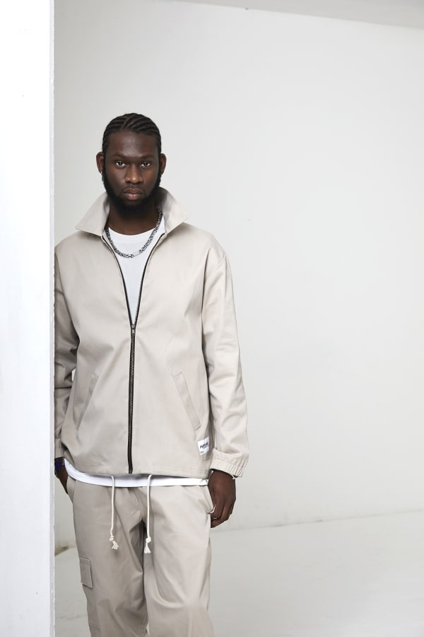 Man standing in beige streetwear