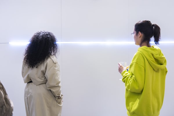 Two young women in front of a white light installaion 