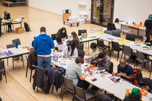 people gathered around a table making lanterns out of paper