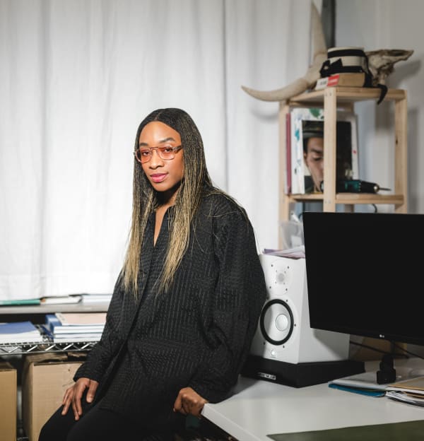 Portrait of a woman standing in front of a desk