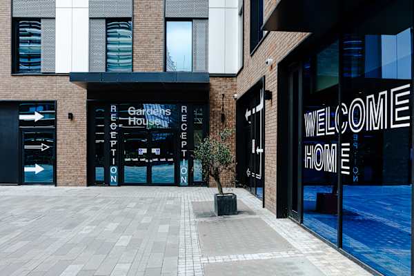 Gardens House reception entrance with 'WELCOME HOME' signage in the window.