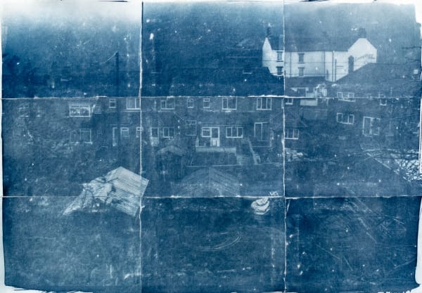 Photograph of houses and gardens, with markings of being folded into sections.