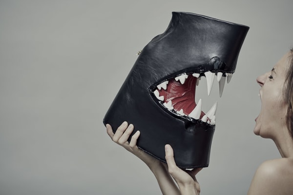 Female model holding shark-themed leather boot
