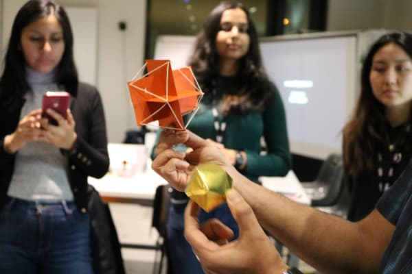 students watching an origami making demonstration