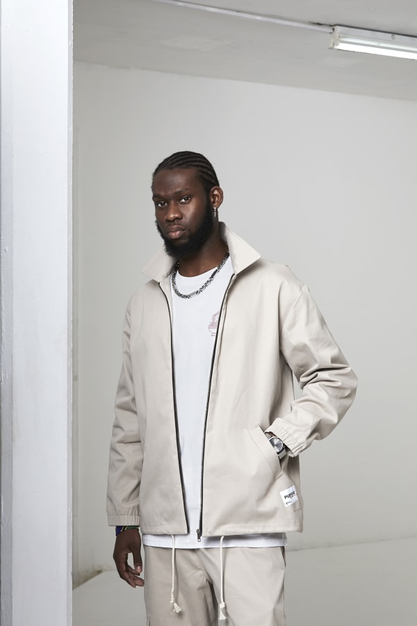 Man standing in beige streetwear