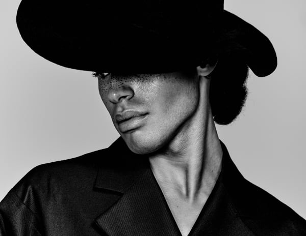 Black and white image of male model in wide brimmed hat