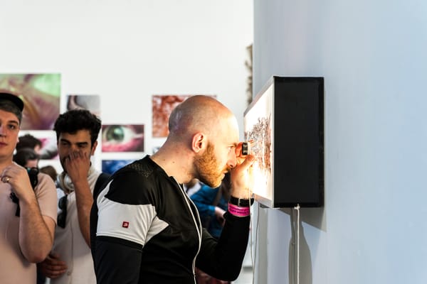 Image of a person viewing a photographic print up close at an exhibition