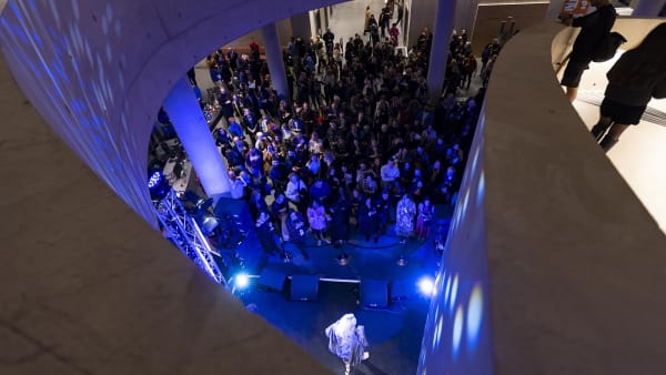 Aerial view of evening event with stage, performer and audience.