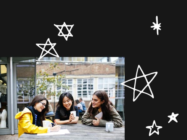 three people sitting and talking round an outdoor table