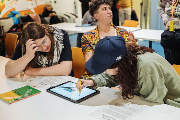 A group of people drawing on an iPad.