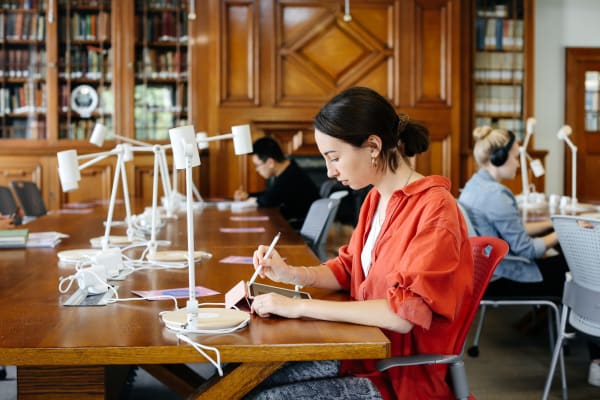 Image of female student working on her tablet in a library