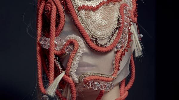 Female model close-up of her face with rope and knit mask detail