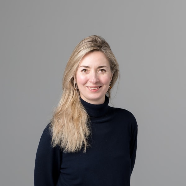 Ewelina Warner in a black dress against a grey background