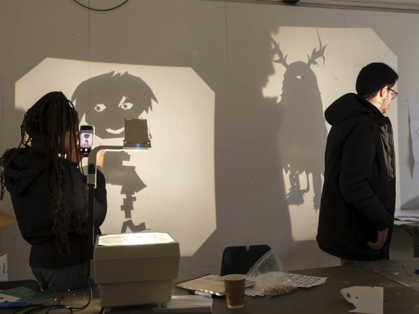 2 students create characters using shadows. 