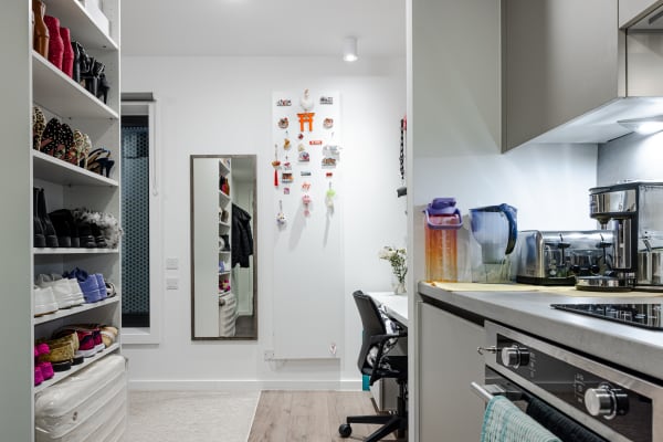 View of a premium studio room featuring a kitchenette with a built-in fridge, combination oven, two hob rings, toaster and sink, separate desk area, entry to bathroom and ample floor space.