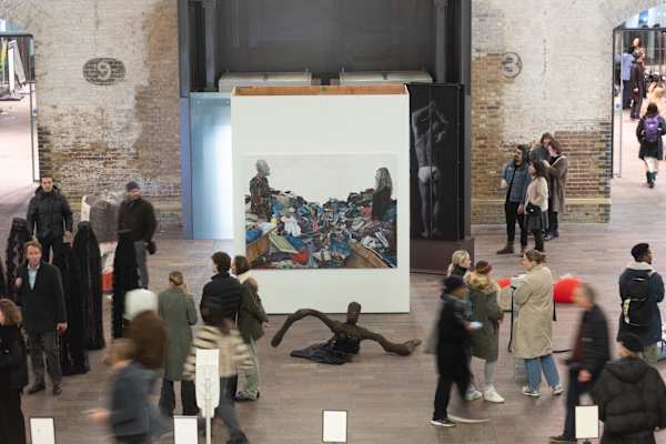 A large installation and sculpture inside the Crossing at Central Saint Martins, which is busy with visitors, shot from a slightly higher angle.
