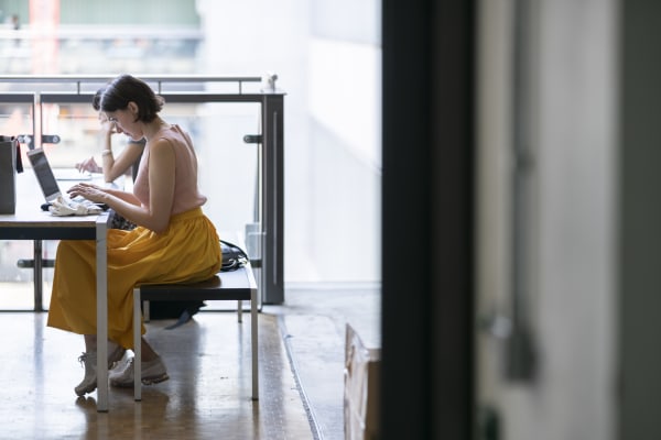 Student in yellow dress studying at a desk