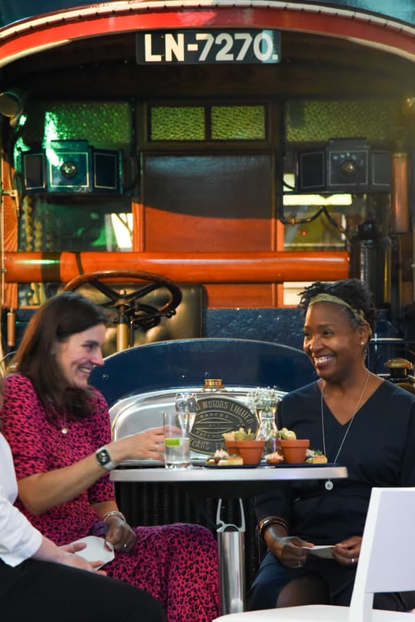 Two people sitting at a table enjoying the reception of the London 2030 exhibition at the London Transport Museum