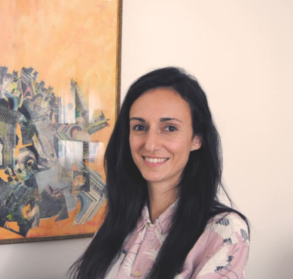 Maribel smiling, next to a painting