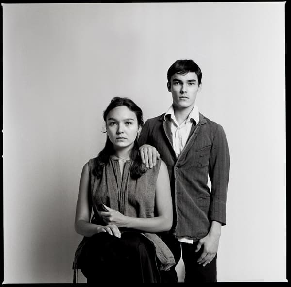 Two people sitting in a traditional portrait-style pose.