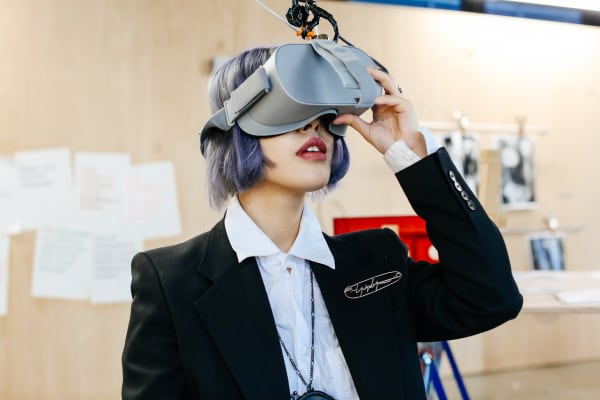 Person with purple hair wearing a virtual reality headset