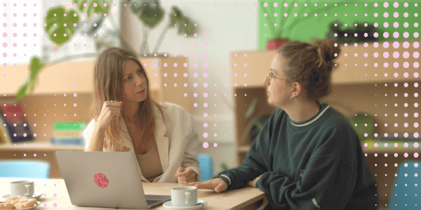 Photograph of two seated people in conversation, over breakfast.