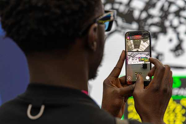 Person looking at phone which is being used as camera to photograph art
