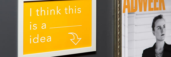 Image of yellow poster in white frame reading 