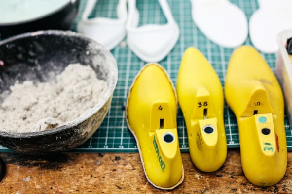 Cutting board with a mixing bowl and a row of yellow shoes