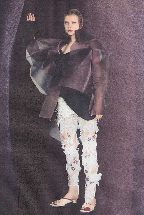 Figure wearing white and mauve garments