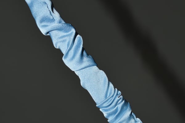 Long pole like sculpture covered by baby blue silk by Hannah Skinner.
