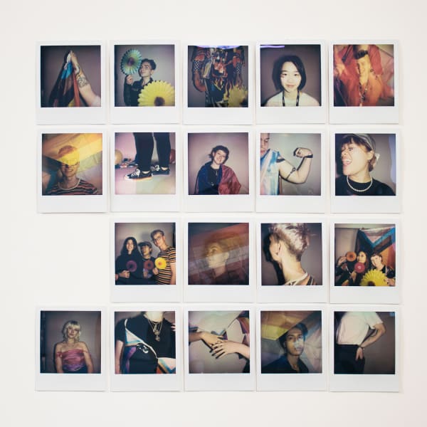 Polaroid photographs arranged in grid on white wall